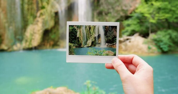 Person, hand and photograph of waterfall in nature travel, landmark or vacation at angel falls in Venezuela. Closeup of traveler holding picture of natural scenery, peaceful river or outdoor memory