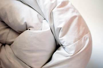 White folded featherduvet in a house.