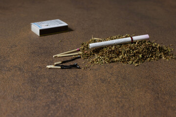 A handful of tobacco, a cigarette and burnt matches.