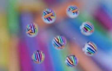 Assortment of pastel color chalk shot through water drops