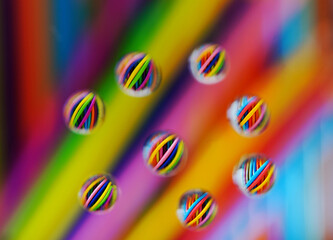 Macro view of assorted colored pencils shot through water droplets