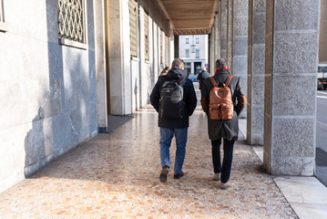 Businessmen walking with their backpacks in Bergamo, Lombardy