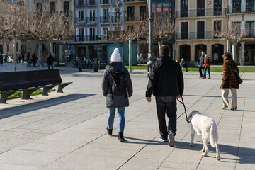 Young couple walking the dog. Castle Square, Pamplona