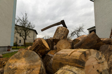 An ax for splitting firewood stuck into a stump for chopping wood.