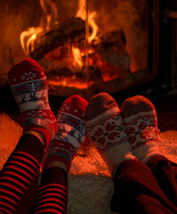 Family in Christmas socks near fireplace. Mother; father and child having fun together. People relaxing at home. Winter holiday Xmas and New Year concept