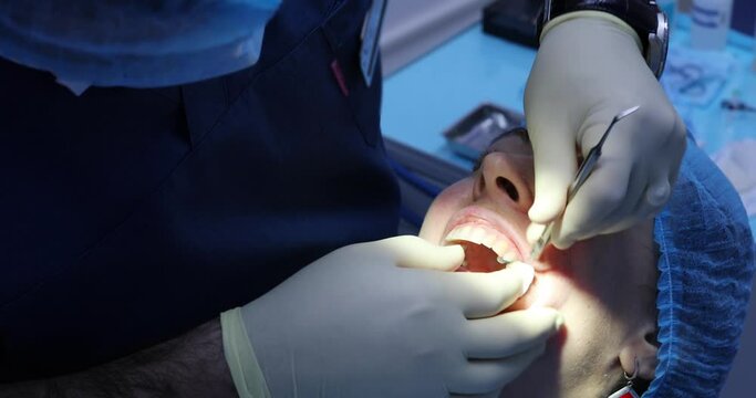 Dentist check teeth with dental instrument for woman patient before tooth treatment