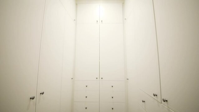 Simple modern white wardrobe with many drawers in apartment