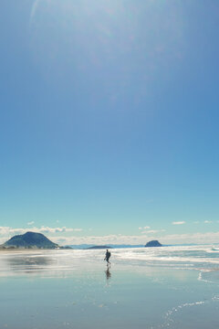 Solo Traveller Walking On A Reflective Beach Shoreline - Work And Travel New Zealand - Tourism Summer Holiday Tropical Paradies Background 