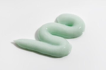Green beauty cream smear on white background. Cosmetic skincare product texture. Face cream, body lotion, swatch