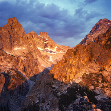 From a small peak above Amphitheater Lake, Nez Perce (left) and Middle Teton (right) bask in summer alpenglow at sunrise. Square format