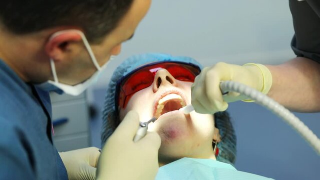 Hands of nurse and doctor washing teeth before dental treatment in clinic, slow motion