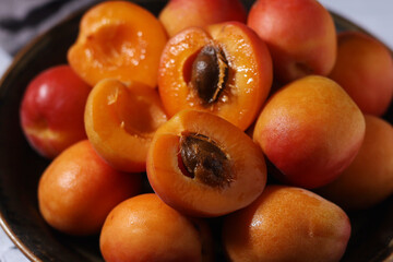 Fresh ripe apricots in bowl in rustic style