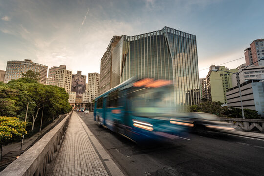 Center of Belo Horizonte during the late afternoon with a public bus in motion and buildings in the background. View of the pedestrian sidewalk of the Santa Tereza viaduct.