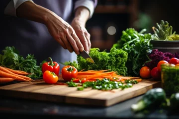 Fotobehang Healthy kitchen prep. hand knife, fresh vegetables for nutritious recipes and organic vegan diet © Mikki Orso