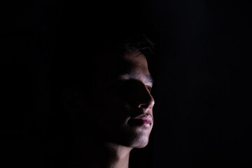 Naklejka premium Portrait for teenager in dark and light studio