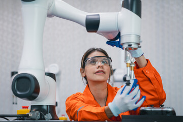 Student engineer Assembling Robotic Arm with computer in Technology Workshop. Service Engineer...