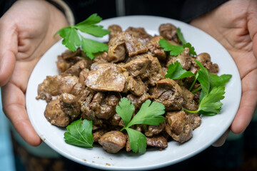 Hands holding dish for gizzard, livers and hearts