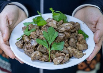 Hands holding dish for gizzard, livers and hearts