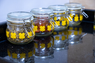 kitchen spices and ingredients jars on black and white background with reflection