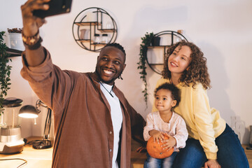 Happy multiracial family taking selfie together in kitchen