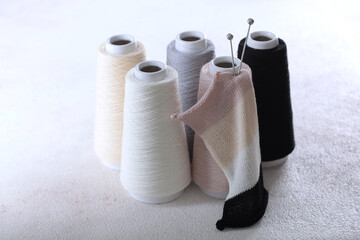 Fototapeta na wymiar Cotton yarn on bobbins. Yarn of warm tones for needlework. Knitting is like a hobby. A pattern for knitting. Copy space. Light background.