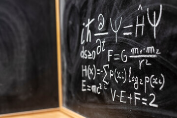 Ecuaciones físicas y matemáticas escrito a mano con tiza en la pizarra