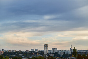 Feather clouds in the evening light on the blue sky over the city.