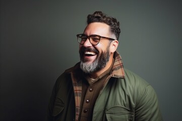 Portrait of a handsome hipster man laughing against a dark background