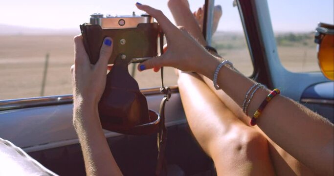 Legs by window, car and photo on road trip, travel or relax on adventure closeup. Hands, camera and vehicle for journey in transport, vacation or person take picture on holiday in the countryside