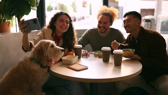 diverse multiracial friends colleagues take a selfie with their dog while having lunch together