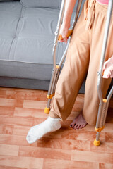 Iron crutches next to a broken female leg in a cast, top view