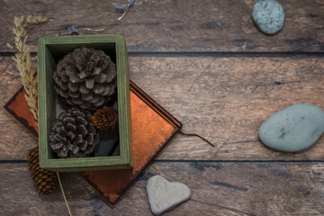 Box with cones on a wooden table, top view. New Year and Christmas retro decorations. Cozy home interior.