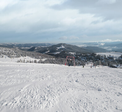 Winter snow covered mountain ski resort slope . Magnificent sunny day on picturesque alpine resort, Dragobrat, Ukraine, Carpathian Mountains. People unrecognizable.