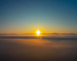Aerial view amazing the sea of mist at beautiful sunrise...slow floating fog blowing cover on the top of mountain look like as a sea of mist. ..white cloud in blue sky over the perfect forest.
