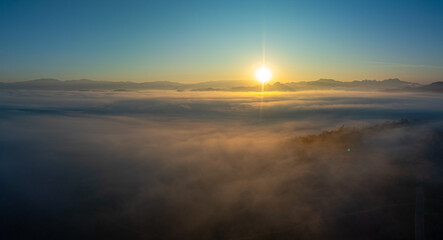 Aerial view amazing the sea of mist at beautiful sunrise...slow floating fog blowing cover on the...