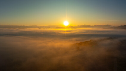 Aerial view amazing the sea of mist at beautiful sunrise...slow floating fog blowing cover on the...