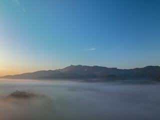 Fototapeta premium Aerial view scenery sunrise above the sea of mist...Nestled amidst the untouched beauty of Tak Province, ..Thi Lo Su Waterfall stands tall as a hidden gem within Umphang Wildlife Sanctuary...