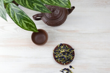 Anchan tea in a dark ceramic plate for a tea ceremony on a light background. view from above