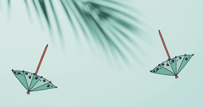 Composition of green cocktail umbrellas falling over palm tree leaves on green background