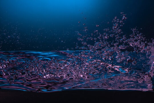 Close-up of vibrant bubbles underwater with a pink hue