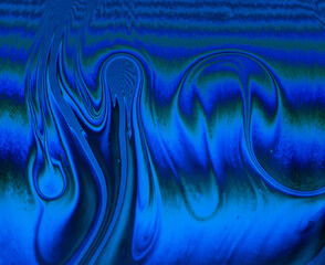 Abstract blue and green wave patterns on a fluid surface