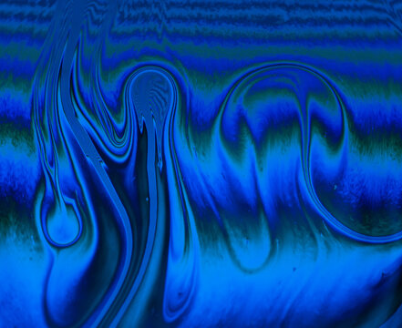 Abstract blue and green wave patterns on a fluid surface