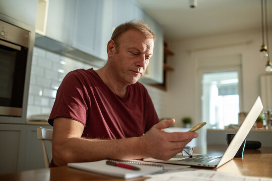 Stressed man going over bills at home