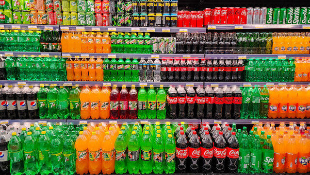 Various carbonated soft drinks kept for sale at a hypermarket shelf