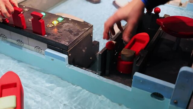  Kids play with toy ships and sluice systems. Slow motion