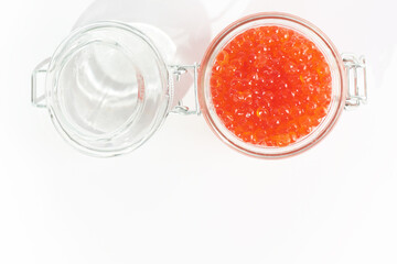 A jar of red caviar on a white background. Red caviar. Salmon roe. Copy space. Isolated object. Top view.