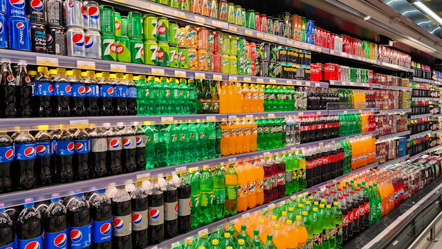 Various carbonated soft drinks kept for sale at a hypermarket shelf