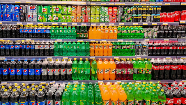 Various carbonated soft drinks kept for sale at a hypermarket shelf