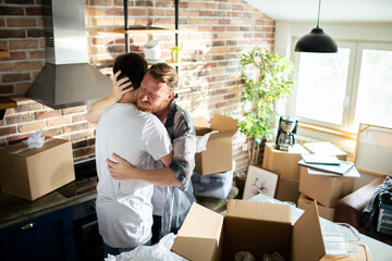 Young male gay couple hugging after moving in - obrazy, fototapety, plakaty