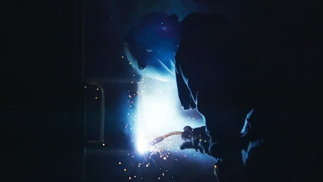 Welding process makes lots of bright fire sparks during detail manufacturing. Welding tool produces orange sparks at the manufacturing facility. Sparks flying out of the manufacturing welding torch